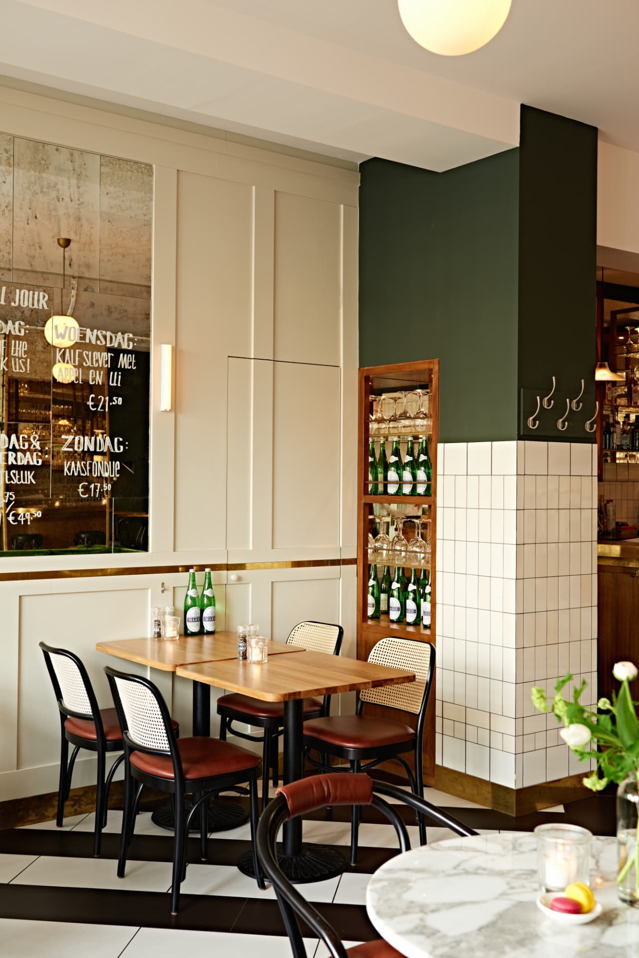 Restaurantinterieur met tafels, stoelen en donkergroene wand
