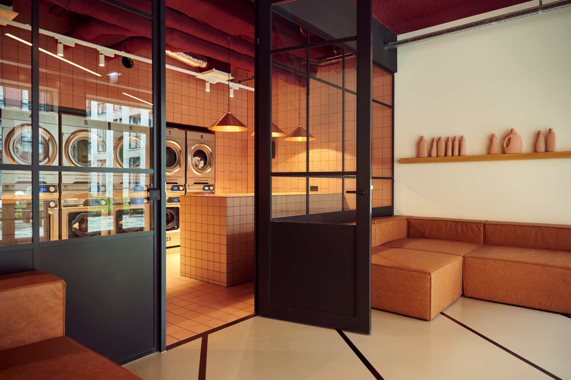Wasserette met terracotta tegels en leren banken bij Our Domain Diemen
