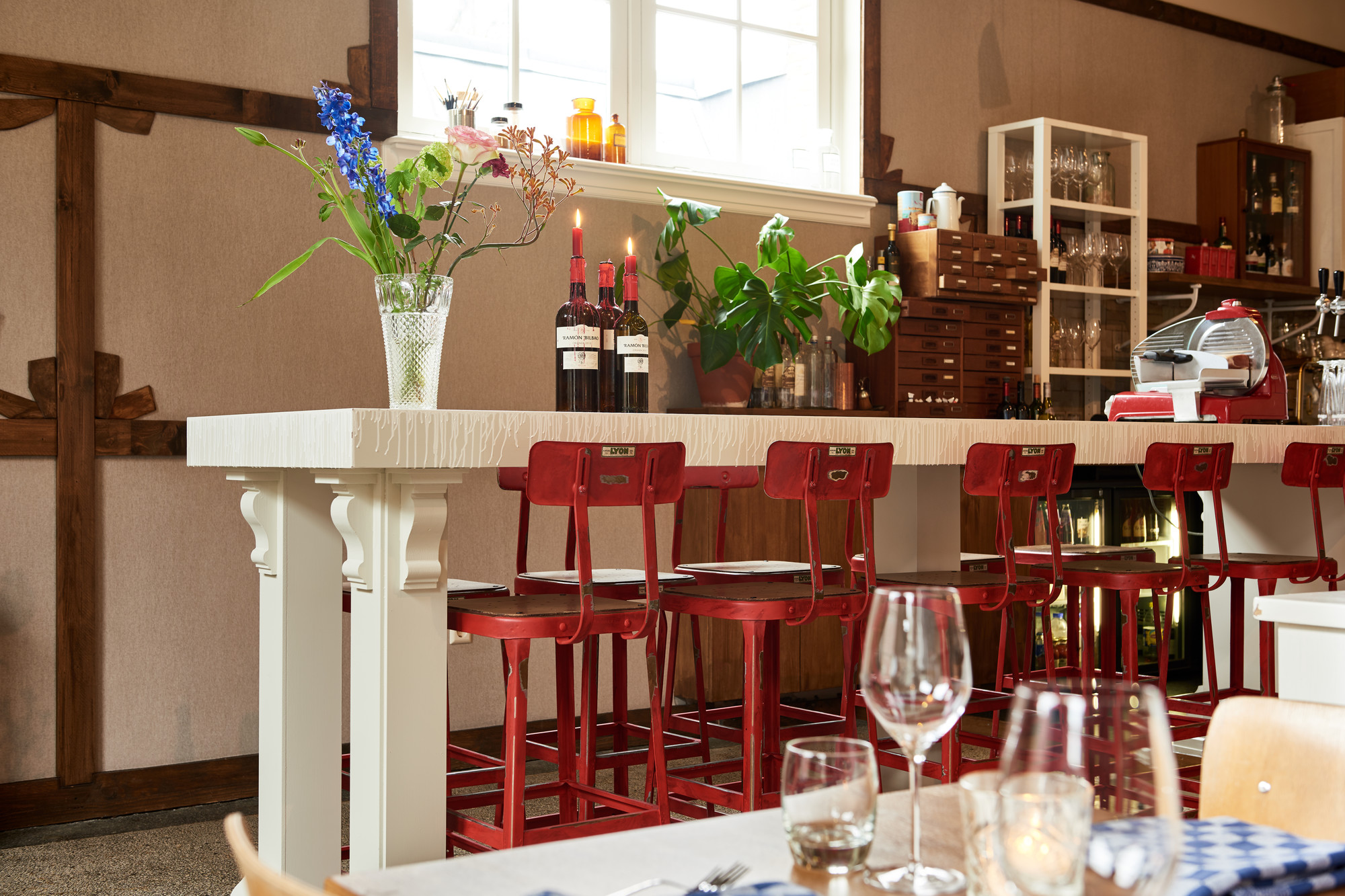 Restaurant Hendrick met rode barkrukken en bloemen