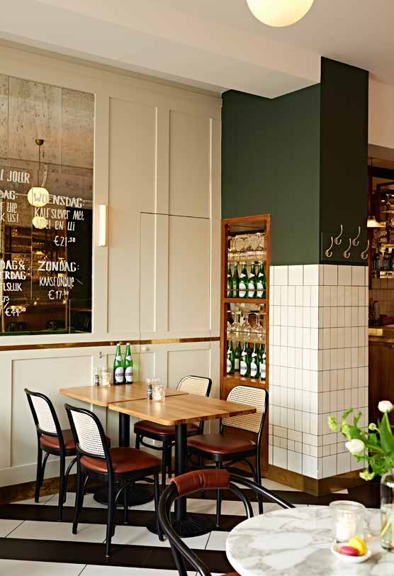 Detail van de zitruimte en groene wand bij Le Quartier