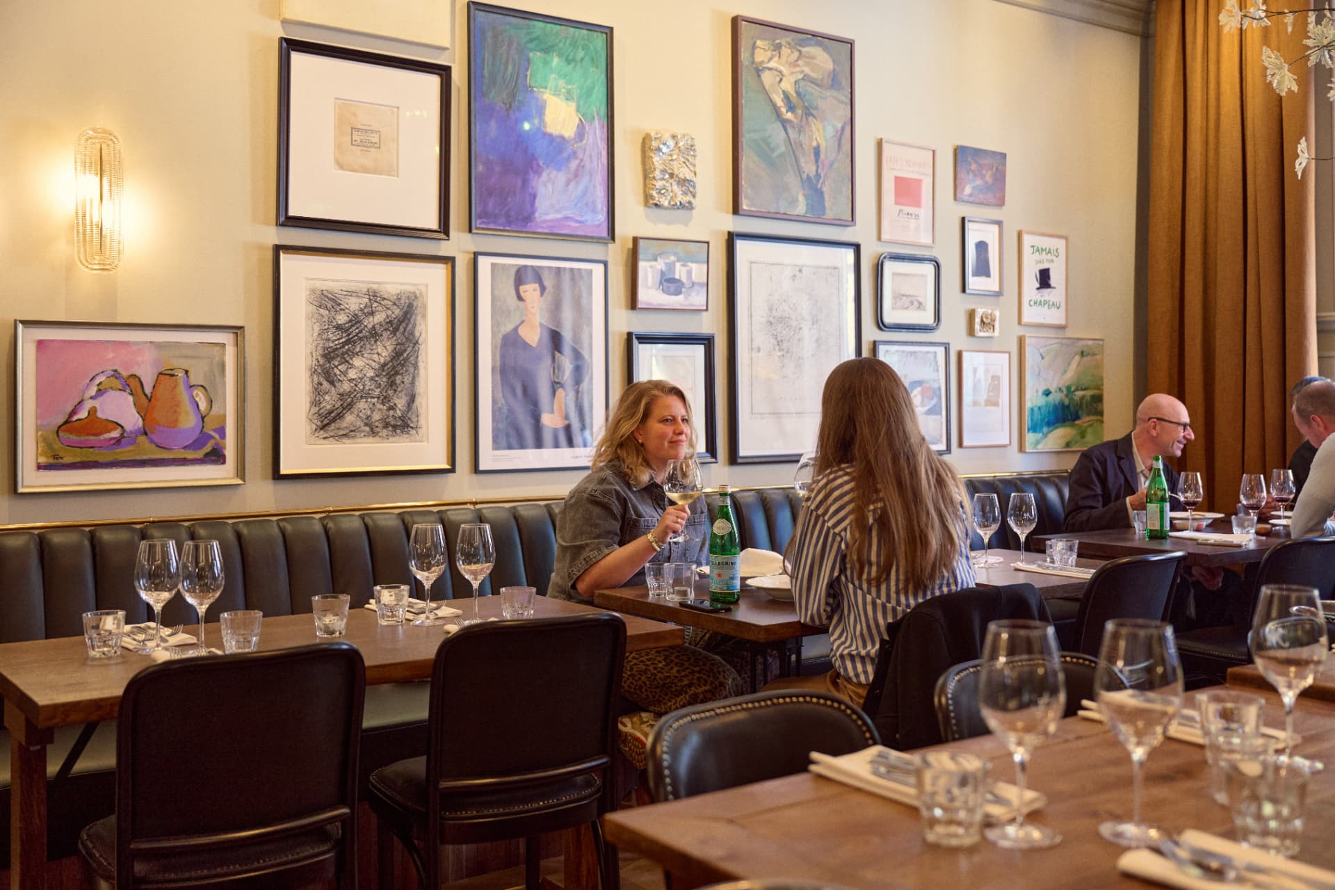 Restaurant Madeleine met gasten en kunst aan de wand