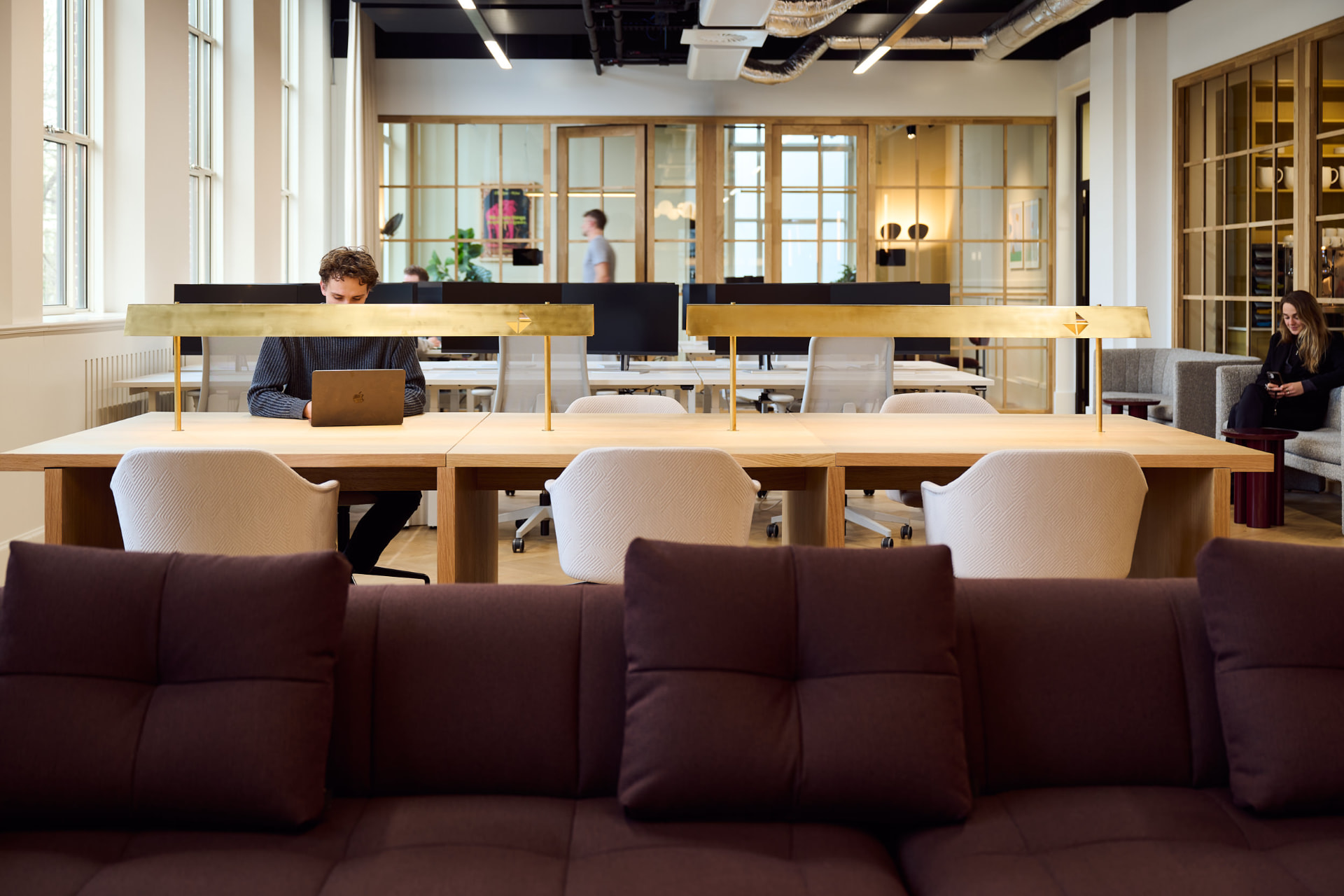Lange werktafel en bruine banken bij Edelman