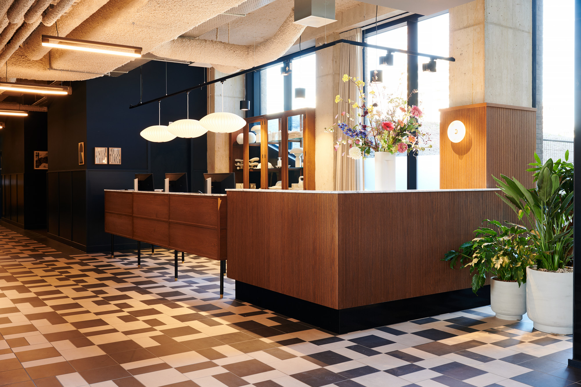 Houten ontvangstbalie met bloemen en papieren hanglampen