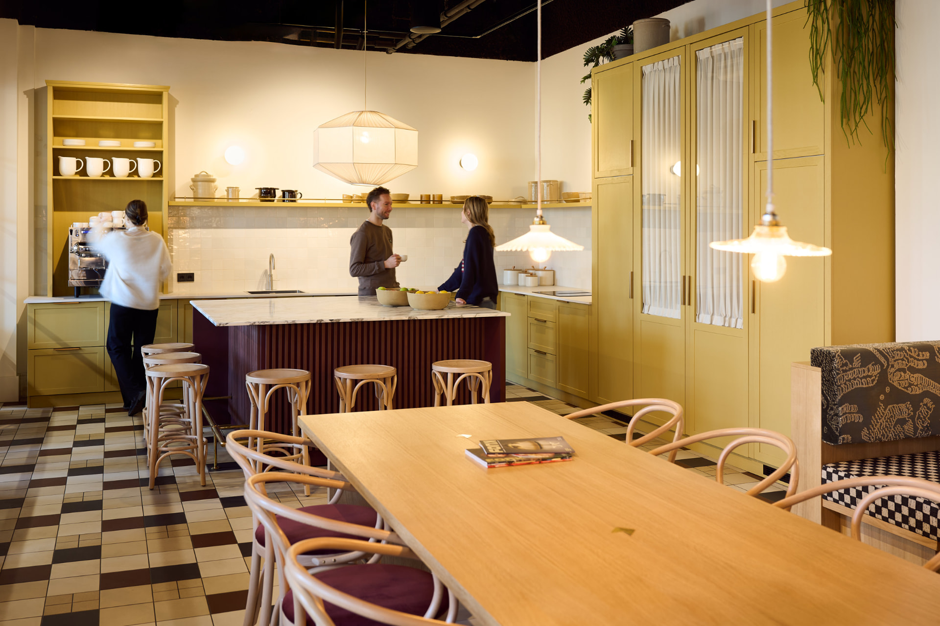 Kantine met gele keuken en lange houten tafel