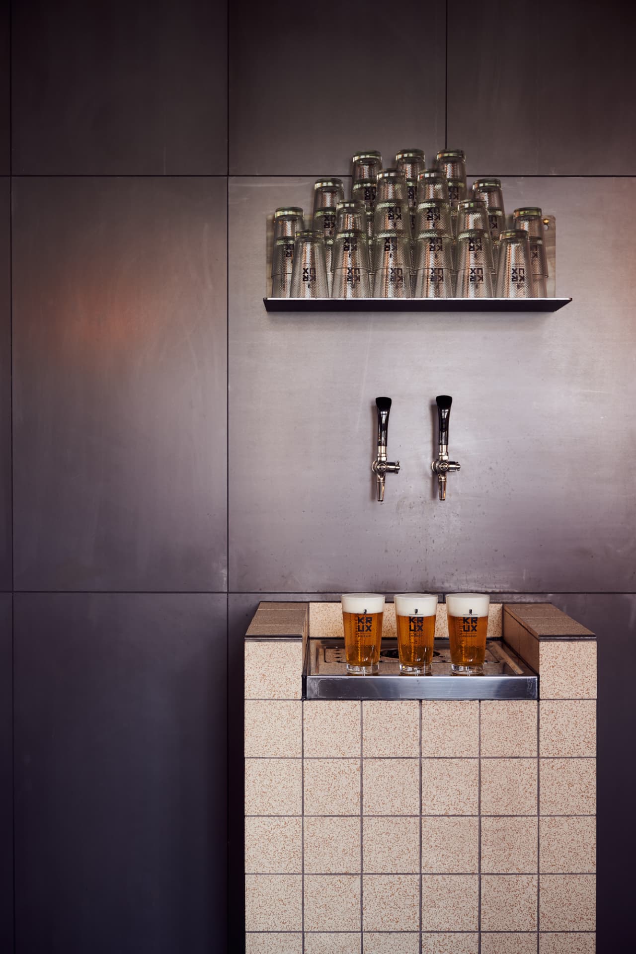 Biertaps op een betegelde wand bij Krux