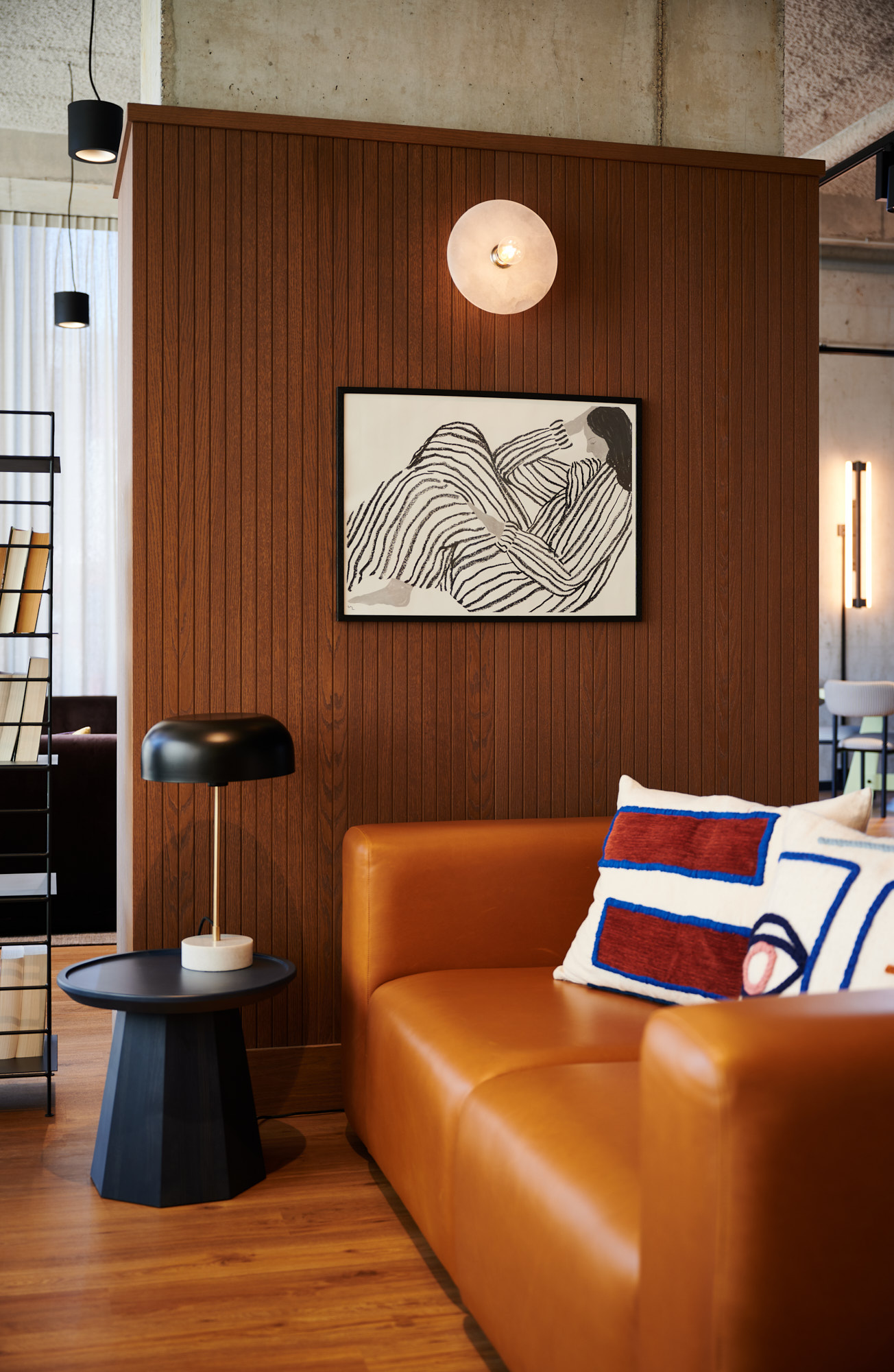 Cognac leren bank voor een houten wand met kunst